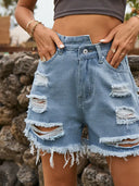 Asymmetriska slitna jeansshorts med fransar