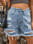 Asymmetriska slitna jeansshorts med fransar